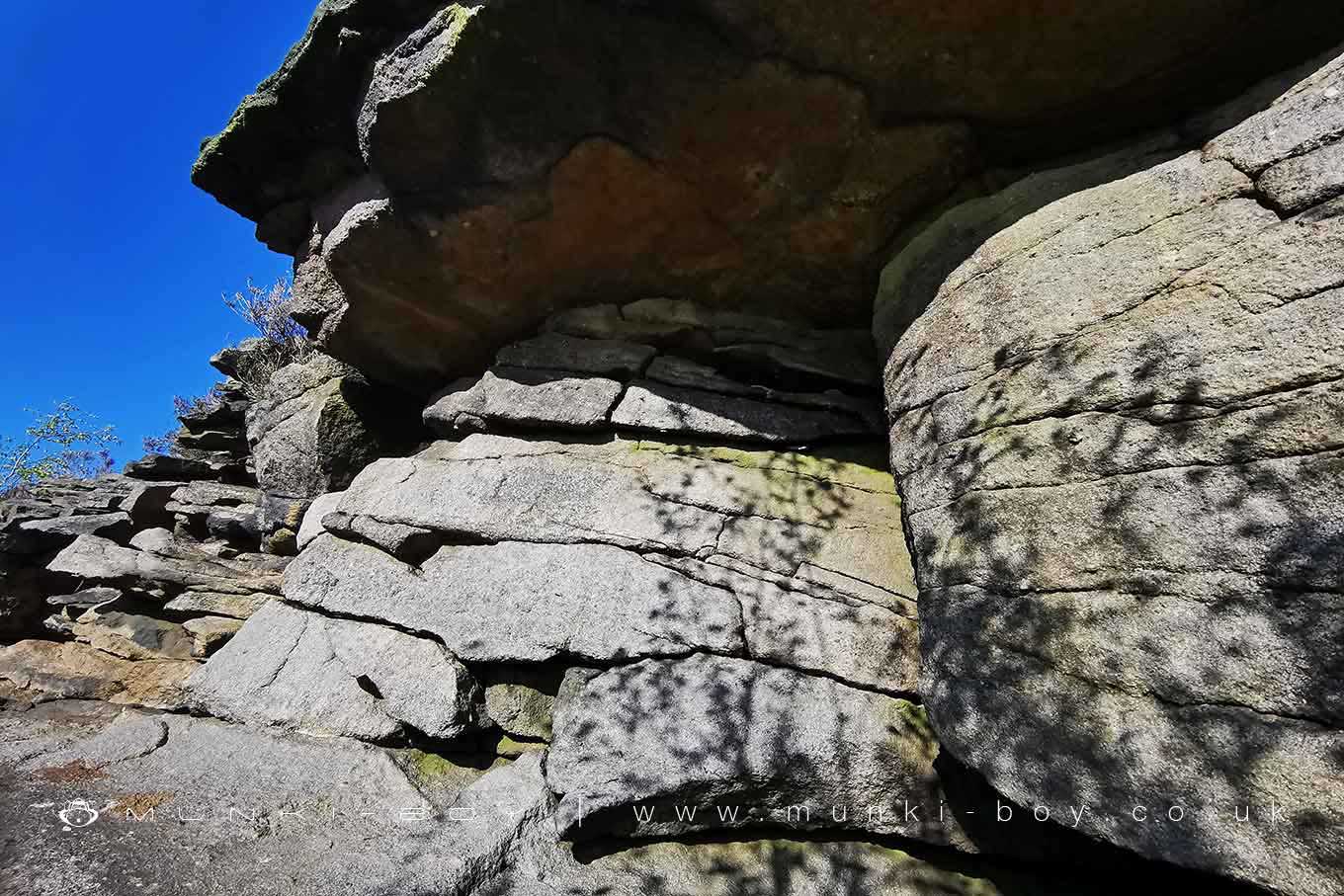 An natural outcrop of Rough Rock under an overhang that looks like a bricked up lead adit from across the valley
